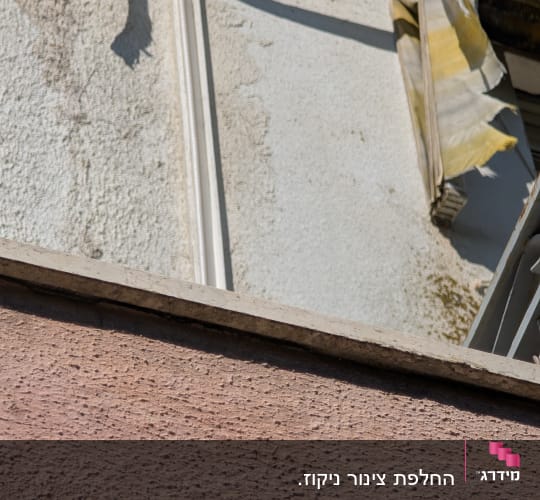 חוטים חשמליים על קיר חיצוני עם טיח מתקלף